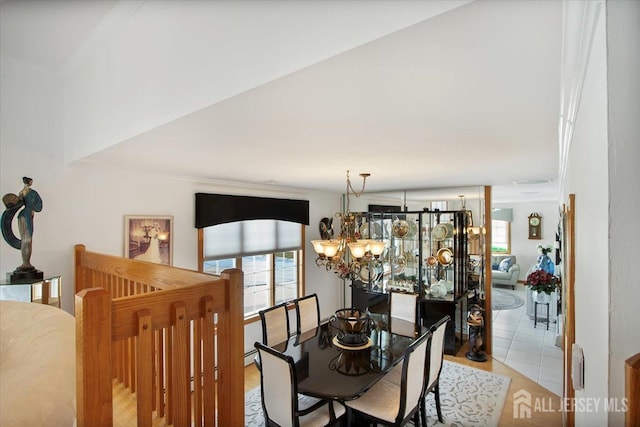 dining space with a chandelier, a healthy amount of sunlight, and light tile patterned flooring