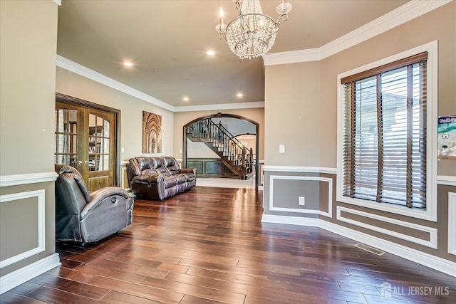 87 Ellmyer Rd, Edison, NJ 08820 - living room featuring arched walkways, a chandelier, ornamental molding, wood finished floors, and stairs