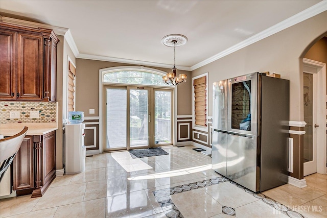 87 Ellmyer Rd, Edison, NJ 08820 - dining space featuring crown molding, arched walkways, a chandelier, a decorative wall, and wainscoting