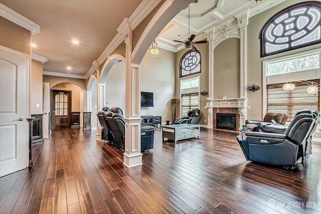 87 Ellmyer Rd, Edison, NJ 08820 - living area with arched walkways, a glass covered fireplace, dark wood-style floors, ceiling fan, and decorative columns