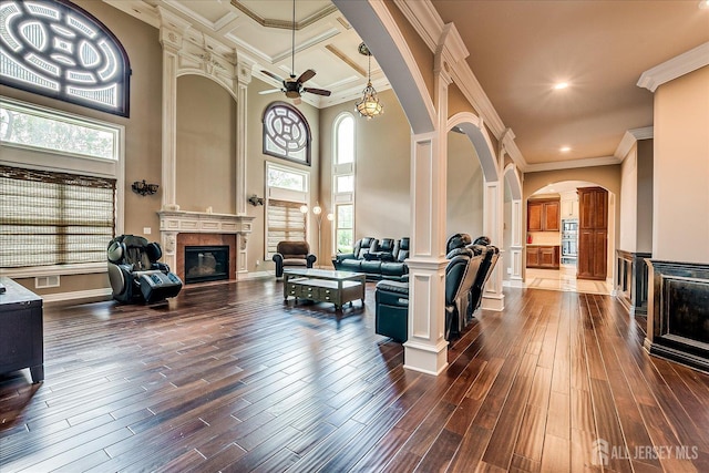 87 Ellmyer Rd, Edison, NJ 08820 - living area featuring arched walkways, a glass covered fireplace, decorative columns, a ceiling fan, and a towering ceiling
