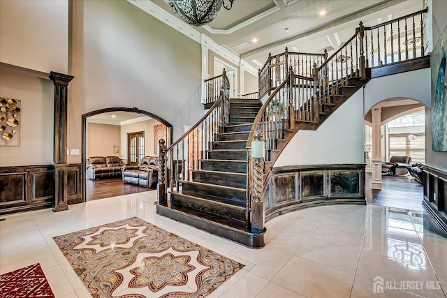 87 Ellmyer Rd, Edison, NJ 08820 - stairway featuring arched walkways, crown molding, a high ceiling, tile patterned floors, and decorative columns