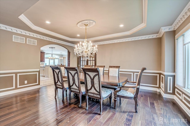 87 Ellmyer Rd, Edison, NJ 08820 - dining room with a chandelier, dark wood finished floors, arched walkways, wainscoting, and a decorative wall