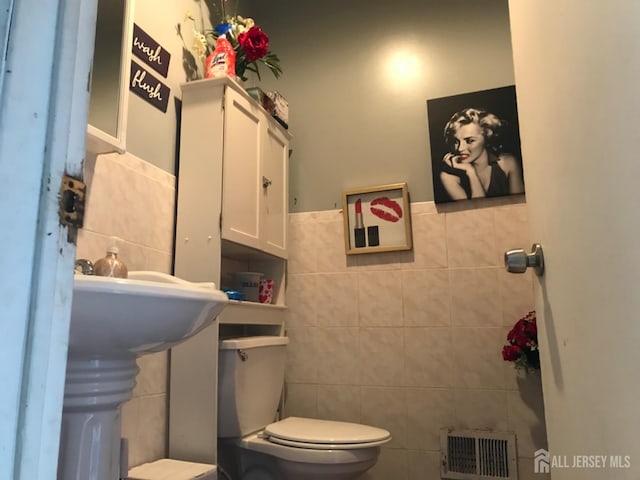335 Alpine St, Perth Amboy, NJ 08861 - bathroom with tile walls, toilet, and a wainscoted wall