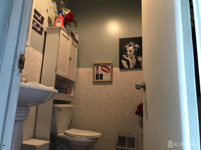 335 Alpine St, Perth Amboy, NJ 08861 - half bathroom with tile walls, toilet, and wainscoting