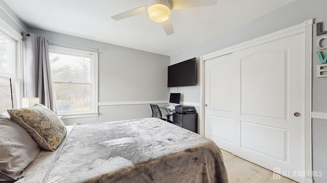 bedroom with ceiling fan, a closet, and light wood-type flooring