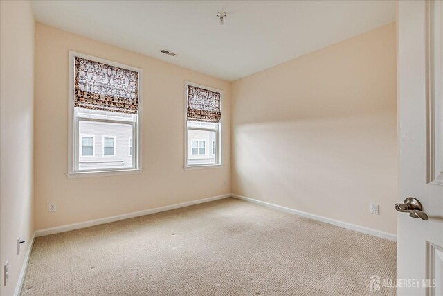 unfurnished room featuring light carpet