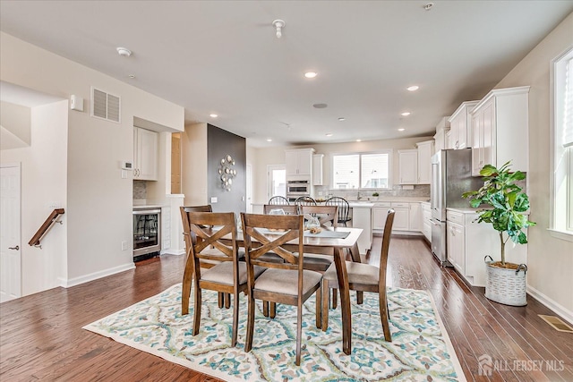 dining room featuring dark hardwood / wood-style floors and beverage cooler