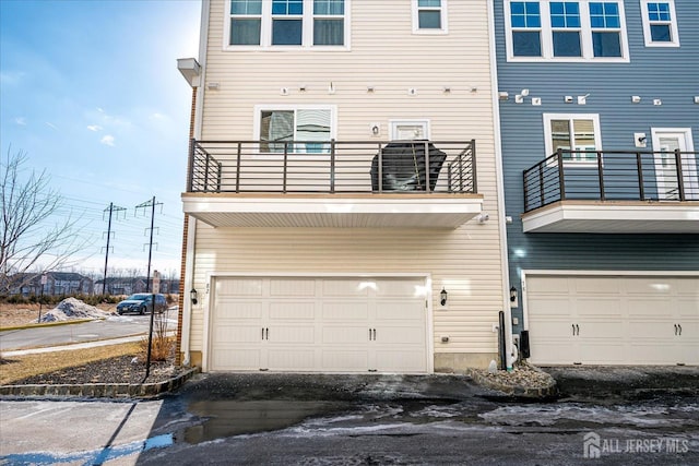 back of property featuring a garage and a balcony