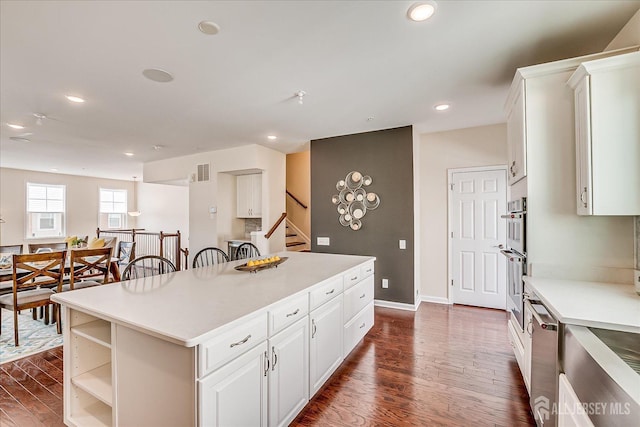 kitchen with white cabinetry, dark wood-type flooring, and a center island