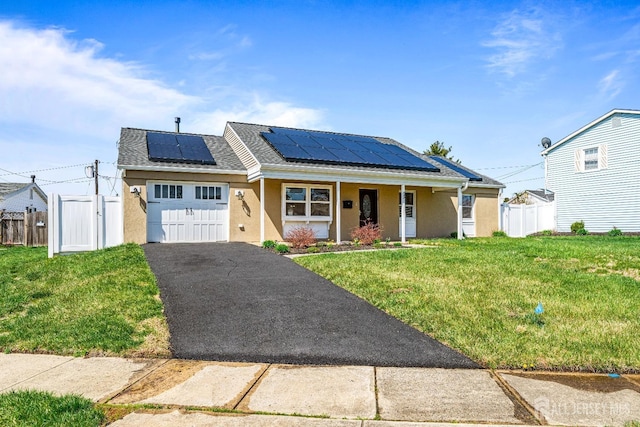 93 Ember Ln, Willingboro, NJ 08046 - view of front of home with an attached garage, stucco siding, asphalt driveway, and solar panels