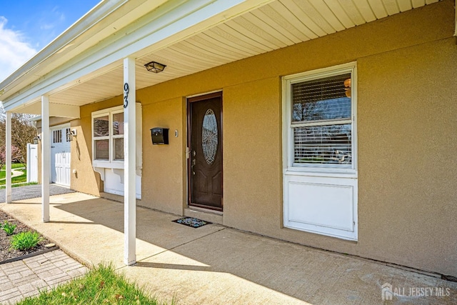 93 Ember Ln, Willingboro, NJ 08046 - view of exterior entry featuring stucco siding and covered porch