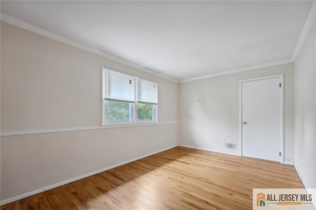 unfurnished room featuring wood-type flooring and ornamental molding