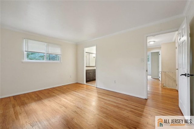 empty room featuring light wood-type flooring, baseboards, and ornamental molding