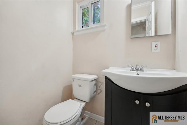 half bathroom featuring baseboards, vanity, and toilet