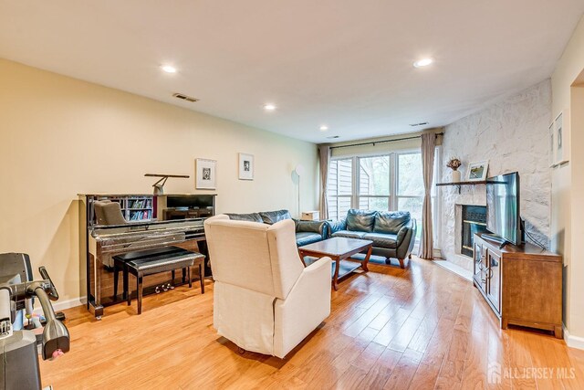142 Maplewood Ct, Edison, NJ 08820 - living room with light wood-type flooring, recessed lighting, a stone fireplace, and baseboards