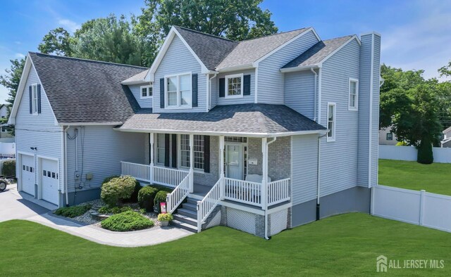 view of front facade with a front yard, a garage, and a porch