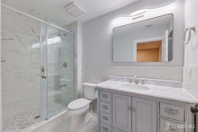 bathroom with a marble finish shower, visible vents, toilet, marble finish floor, and vanity