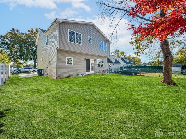 rear view of house featuring a lawn