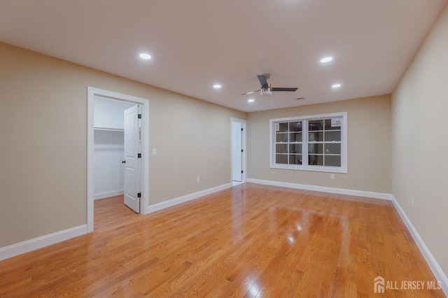 spare room with baseboards, light wood-type flooring, a ceiling fan, and recessed lighting