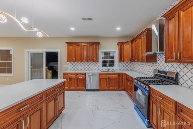 kitchen featuring marble finish floor, visible vents, appliances with stainless steel finishes, a sink, and wall chimney exhaust hood