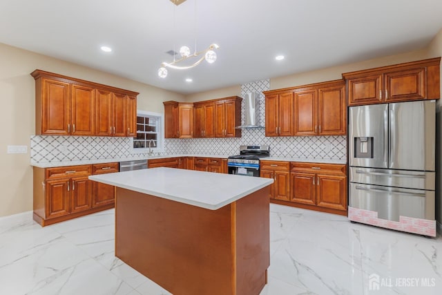 kitchen featuring brown cabinetry, appliances with stainless steel finishes, marble finish floor, wall chimney range hood, and a sink