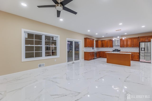 kitchen featuring recessed lighting, stainless steel appliances, a kitchen island, visible vents, and marble finish floor