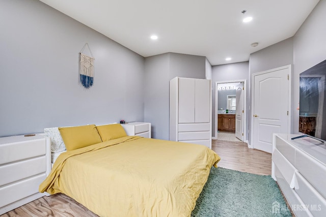 bedroom featuring wood-type flooring and ensuite bath