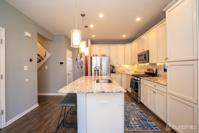 4 Woodrose Ln, Monroe, NJ 08831 - kitchen with dark wood finished floors, an island with sink, a sink, decorative backsplash, and appliances with stainless steel finishes