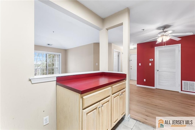 kitchen featuring light wood-type flooring, dark countertops, visible vents, and ceiling fan