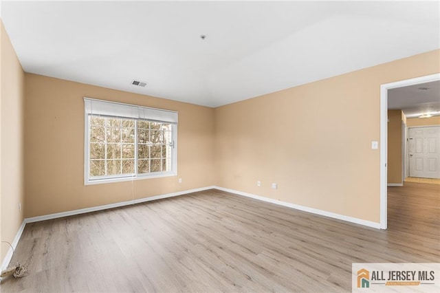 spare room with visible vents, baseboards, and wood finished floors