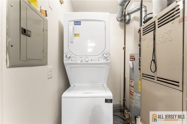 laundry area featuring heating unit, stacked washer / drying machine, water heater, laundry area, and electric panel