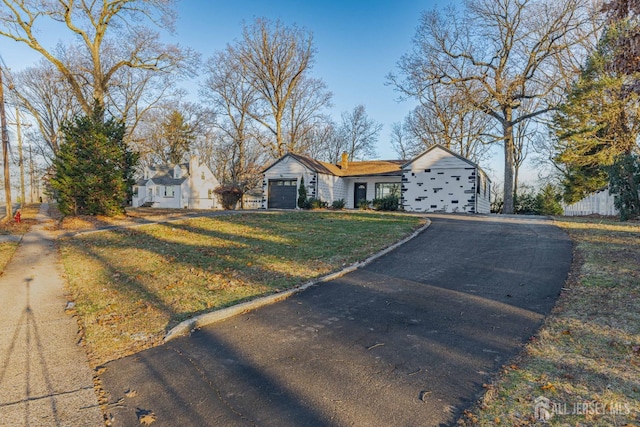 ranch-style house featuring a garage and a front yard