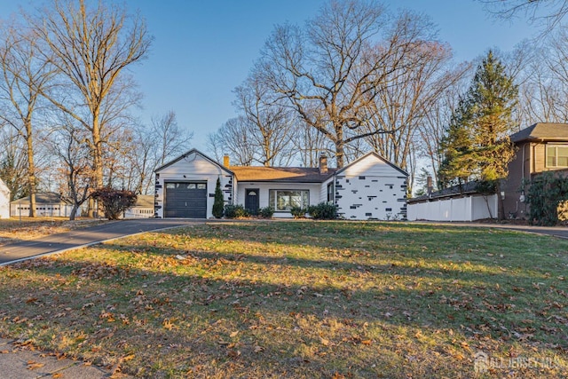 ranch-style home featuring a garage and a front lawn