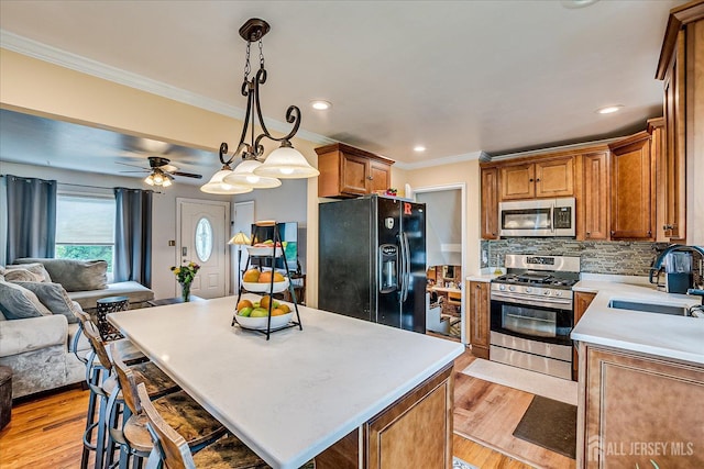 6 Dundar Rd, Edison, NJ 08817 - kitchen with appliances with stainless steel finishes, open floor plan, ornamental molding, light countertops, and backsplash