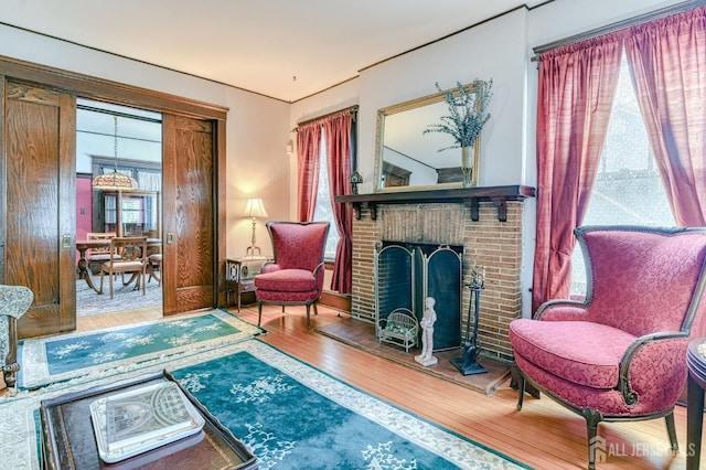 living area featuring wood finished floors and a brick fireplace