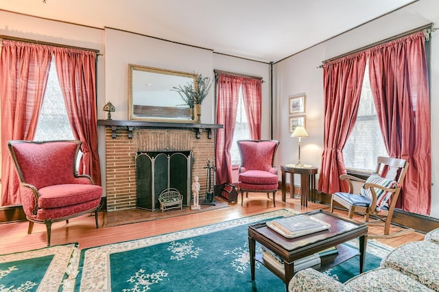 sitting room with a fireplace and wood finished floors