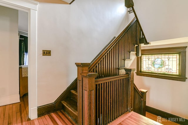 stairway featuring wood-type flooring and baseboards