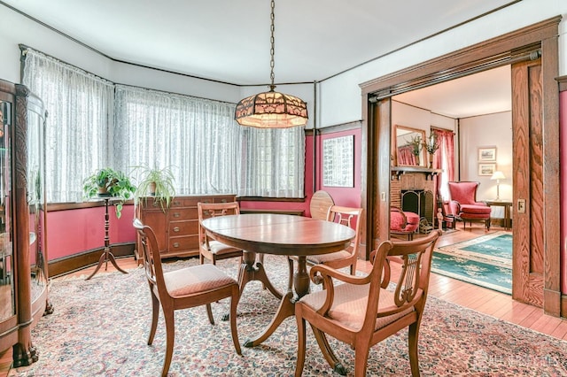 dining area with a brick fireplace and hardwood / wood-style flooring