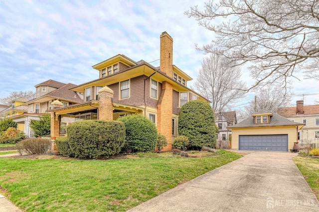 american foursquare style home featuring a front yard, a chimney, and an outbuilding