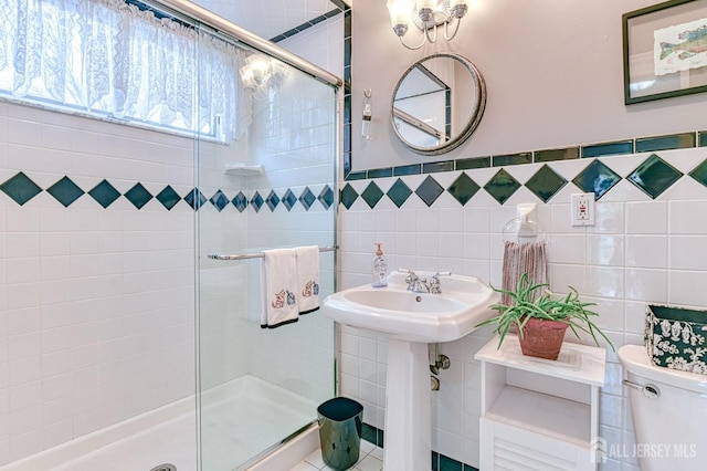 full bathroom with toilet, tile walls, a sink, and a stall shower