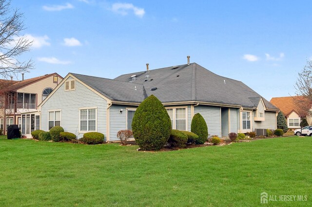 rear view of house featuring a yard and central air condition unit