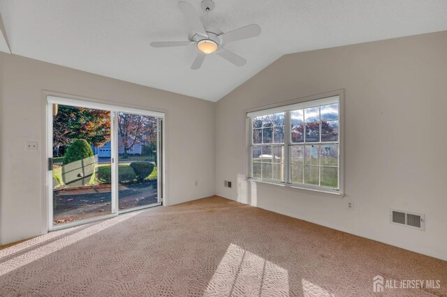 unfurnished room with carpet flooring, vaulted ceiling, and ceiling fan