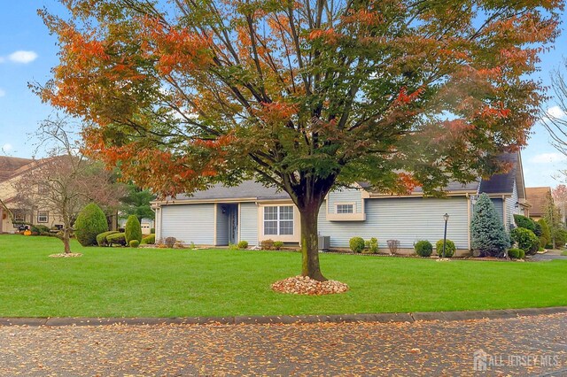 view of front of property with cooling unit and a front lawn