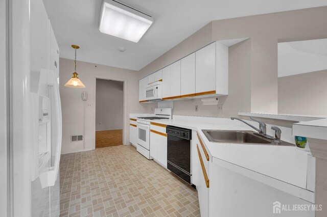 kitchen with pendant lighting, white cabinetry, white appliances, and sink