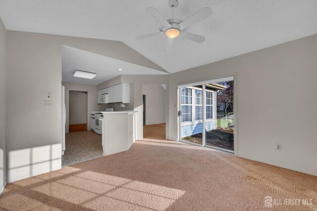 unfurnished living room featuring ceiling fan, light colored carpet, and lofted ceiling