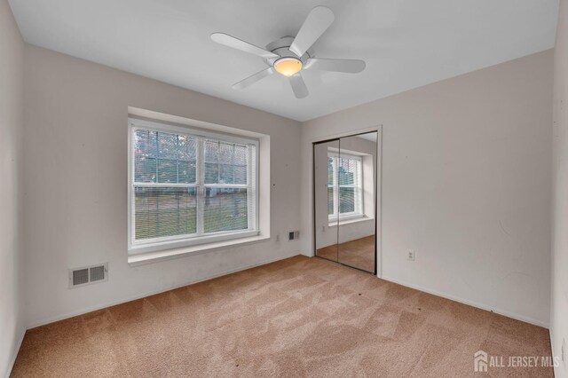 spare room featuring ceiling fan and light carpet