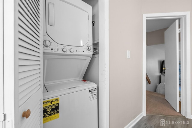 1058 Schmidt Ln, North Brunswick, NJ 08902 - laundry room featuring stacked washer / drying machine, wood finished floors, and baseboards