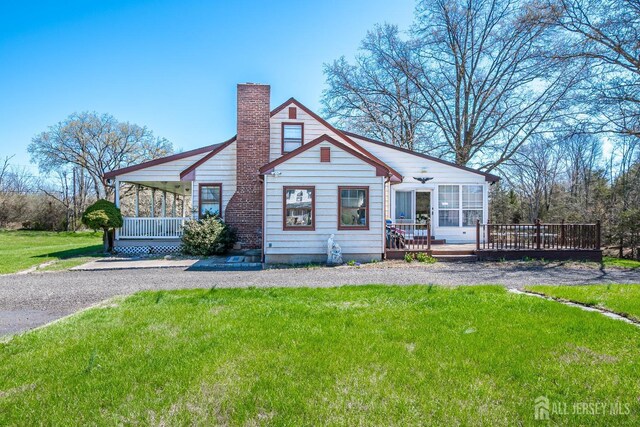 80 Gates Rd, Franklin Twsp, NJ 08873 - view of front of property with a chimney, a wooden deck, a front lawn, and covered porch