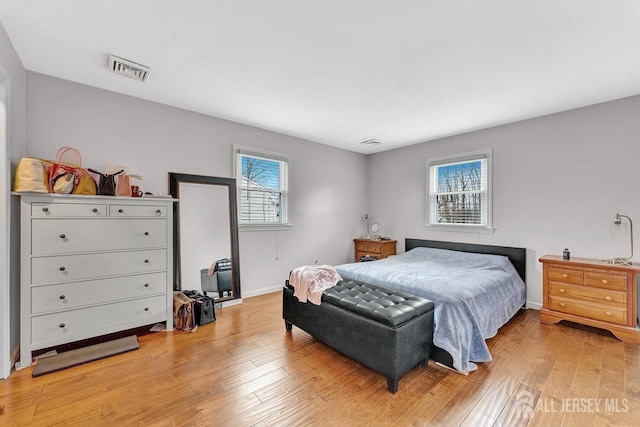 bedroom featuring light wood-type flooring, baseboards, and visible vents